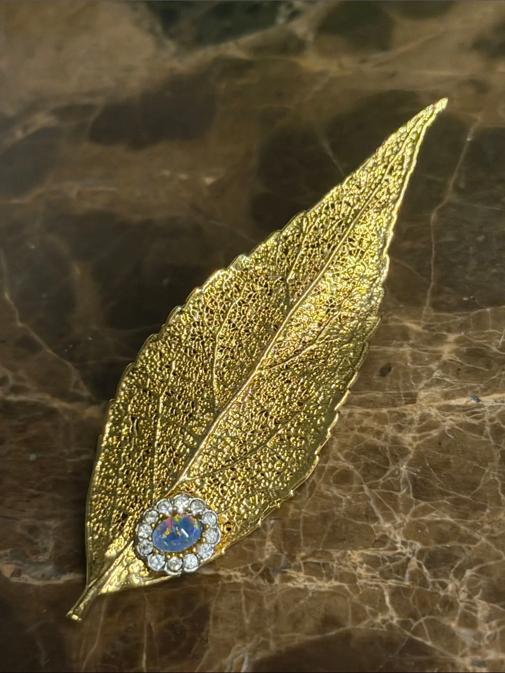 Beautiful gold plated leaf with a cabochon opal and crystal surrounding